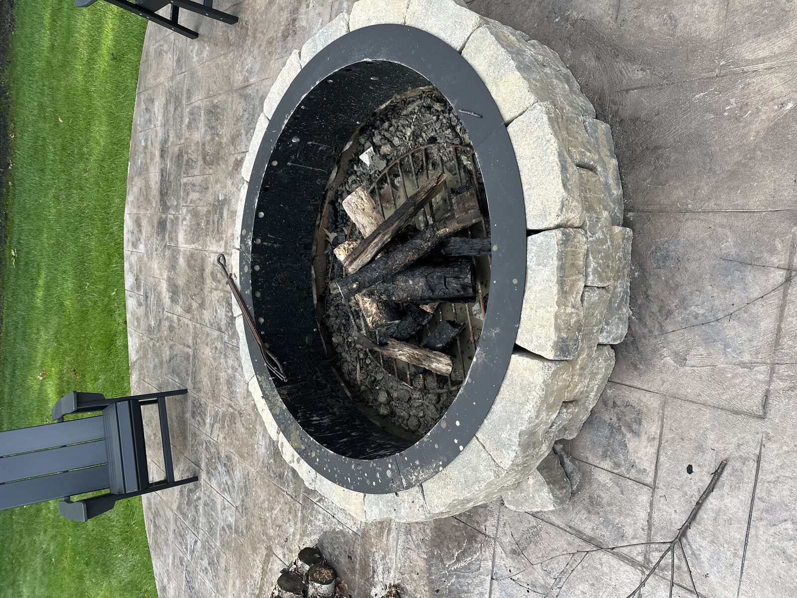 Stone block fire pit on a stamped concrete patio