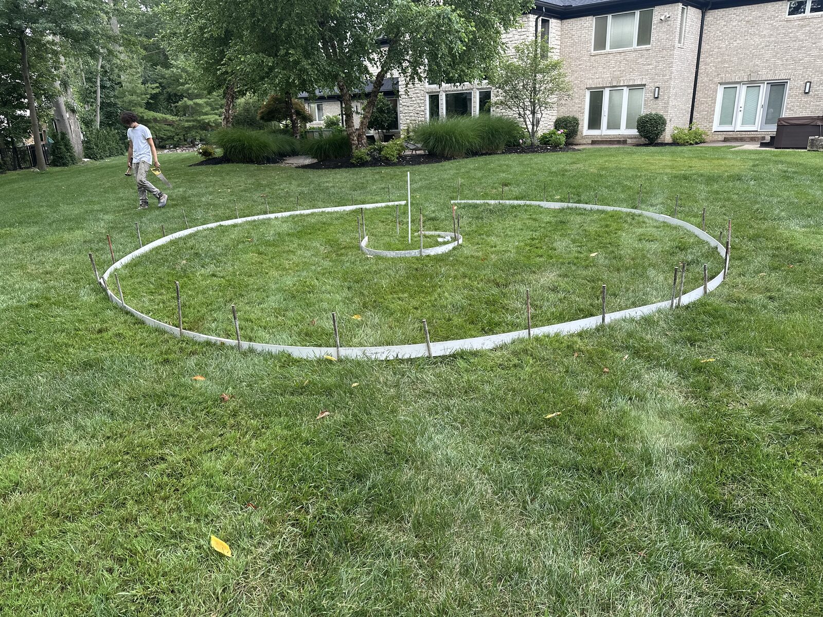 Circular patio layout staked out on a residential lawn
